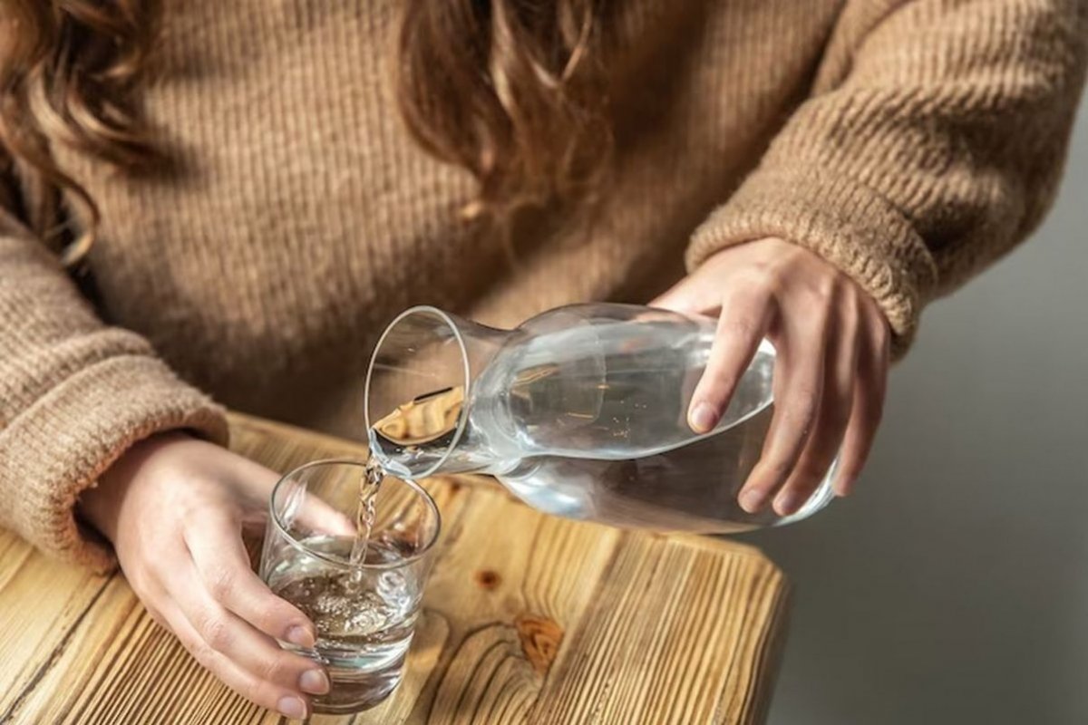 лить воду в стакан